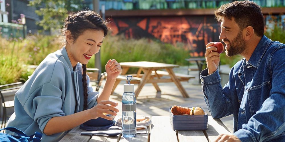 Gebrandete Werbeartikel mit Firmenlogo ? Tasse, Trinkflasche und Notizbuch als Teil der Employer-Branding-Strategie.