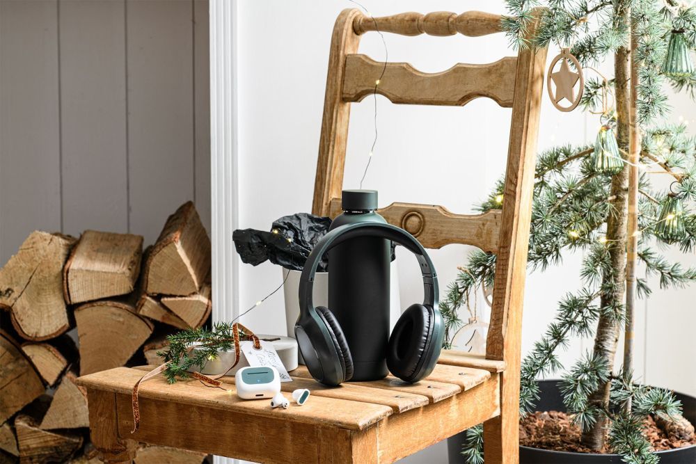 Übergabe von Weihnachtsgeschenken im Unternehmen ? Mitarbeitende freuen sich über Geschenksets mit Logo und weihnachtlicher Verpackung.