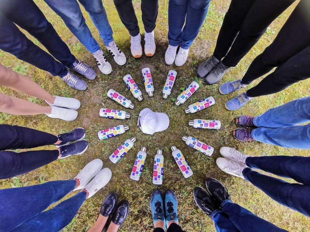 Flach gelegtes Willkommenspaket mit gebrandetem Notizbuch, Kopfhrern, Trinkflasche und Broartikeln ? modernes Onboarding und effektive Arbeitgebermarke